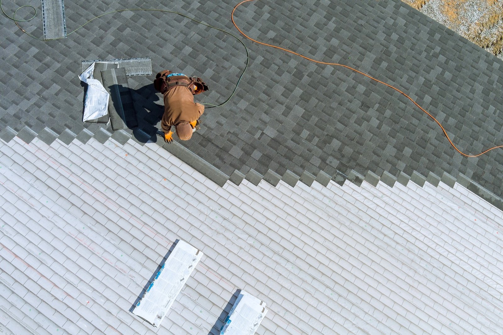 Un ouvrier installant des bardeaux sur le toit d'une maison