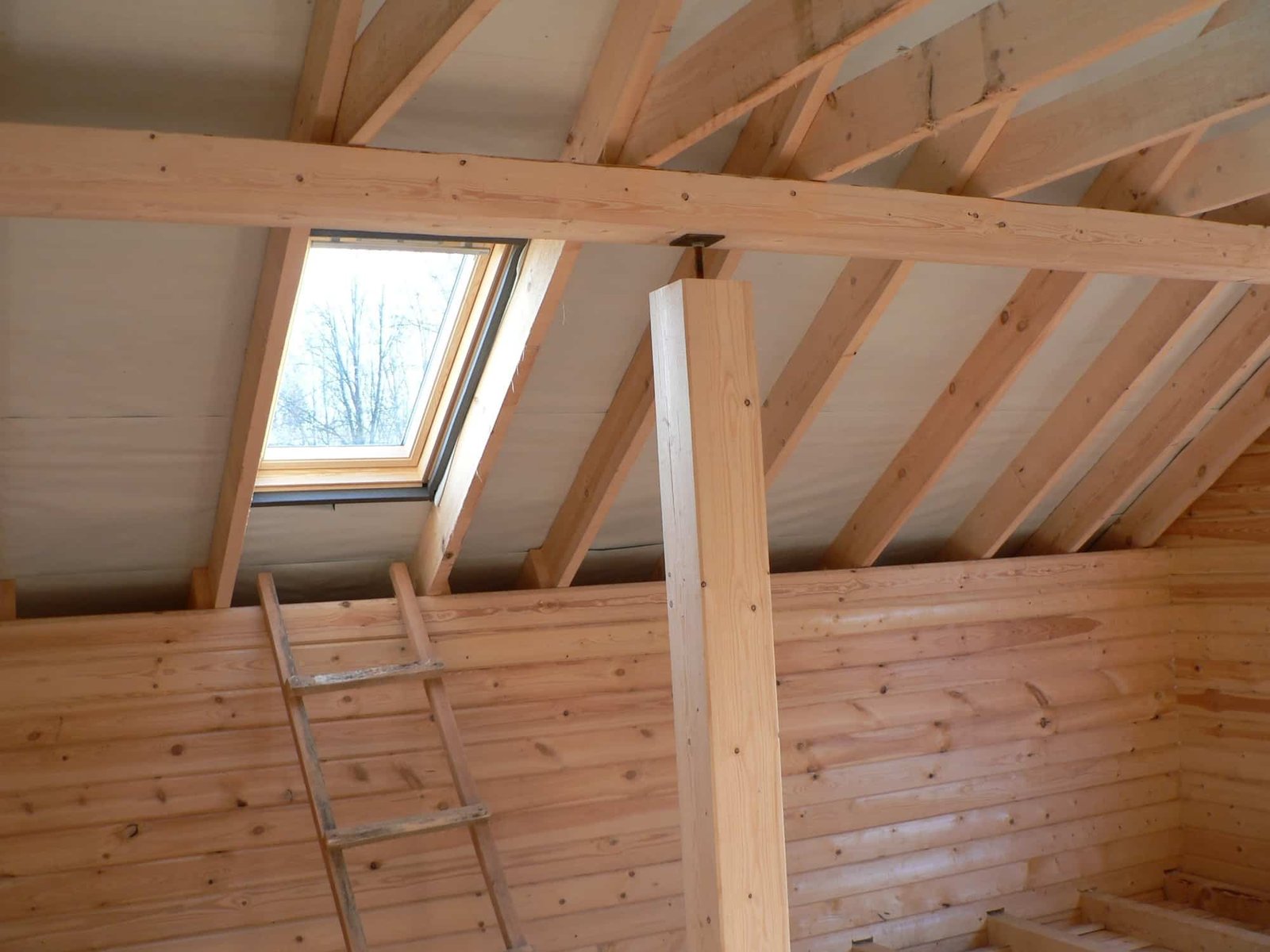 Construction d'une maison en bois, vue sur le toit avec fenêtre.