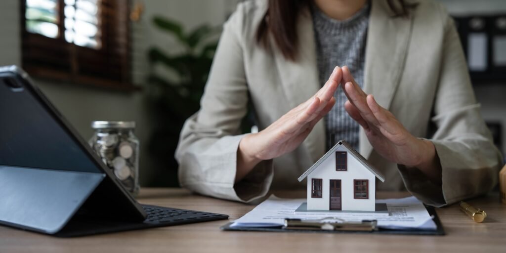 real estate agent use their hands to protect the red roofs, the concept of protecting houses using